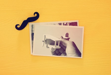top view of photo collage on yellow wooden background. vintage filtered imageの写真素材