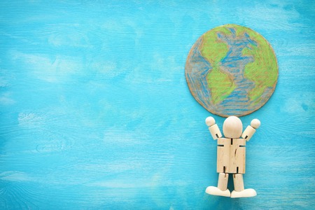 image of wooden figure holding a globe. learning and education conceptの写真素材