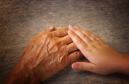 image of old man and a kid holding hands togetherの写真素材