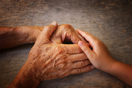 image of old man and a kid holding hands togetherの写真素材