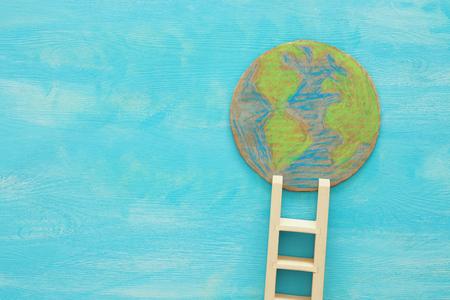 top view image of earth globe and ladder over blue wooden backgroundの写真素材