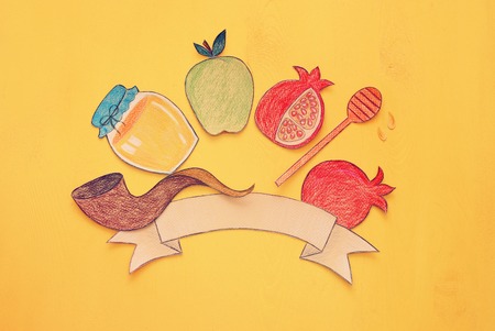 Rosh hashanah (jewish New Year holiday) concept. Traditional symbols shapes cut from paper and paintedの写真素材