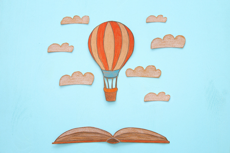 Hot air balloon, space elements shapes cut from paper and painted over wooden blue backgroundの写真素材