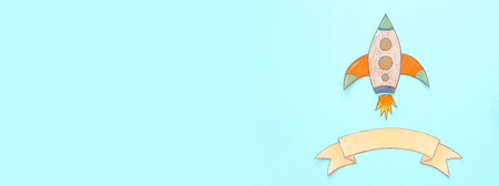 Banner of Rocket cut from paper and painted over wooden blue backgroundの写真素材