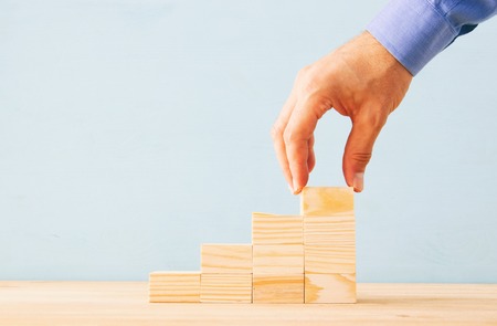 businessman arranging wood blocks stacking as step stairs. success and development conceptの写真素材