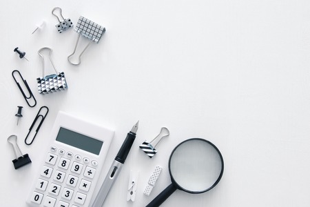 White office desk table with calculator and other office supplies. Top viewの写真素材