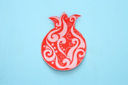 Rosh hashanah (jewish New Year holiday) concept. Traditional symbol POMEGRANATE shape cut from paper and paintedの写真素材