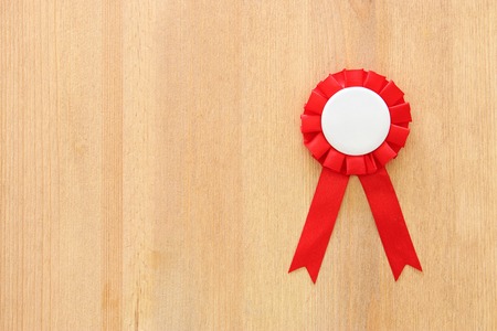 red award ribbon over wooden tableの写真素材