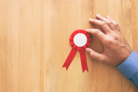 red award ribbon over wooden tableの写真素材