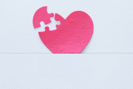 Top view image of paper pink heart puzzle with missing piece over white background. Health care, donate, world heart day and world health day conceptの写真素材