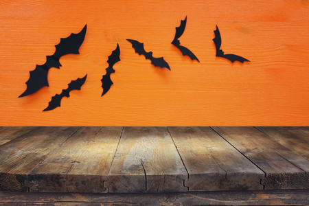 Halloween holiday concept. Empty rustic table in front of black bats background. Ready for product display montageの写真素材