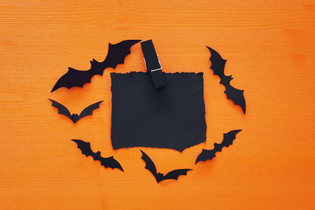 Halloween holiday minimal top view image of empty letter to add text over orange wooden background. Card and invitation conceptの写真素材
