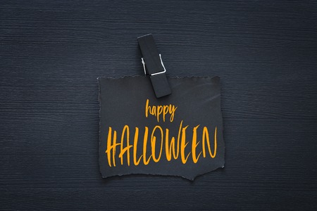 Halloween holiday minimal top view image of letter with text HAPPY HALLOWEEN over wooden background. Card and invitation conceptの写真素材