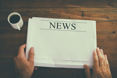 top view image of male hand holding blank Newspaper with empty space to add news or text. retro style imageの写真素材