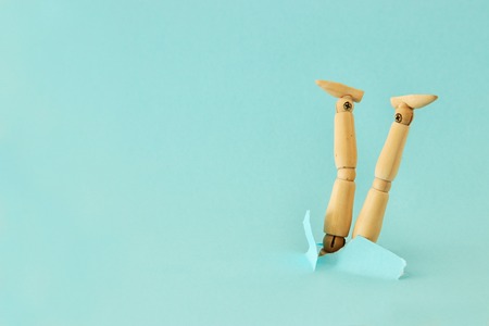 concept image of wooden dummy stuck upside down. stress and danger conceptの写真素材