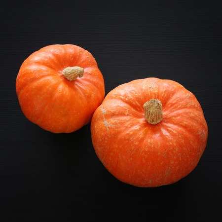Halloween holiday minimal top view image of pumpkin over black wooden backgroundの写真素材