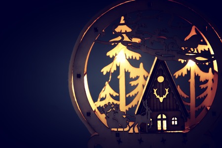 Low key Image of magical Christmas scene of wooden pine forest, hut and Santa Claus over sleigh with...