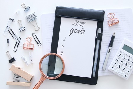 Top view 2019 goals list with notebook and calculator over wooden white deskの写真素材