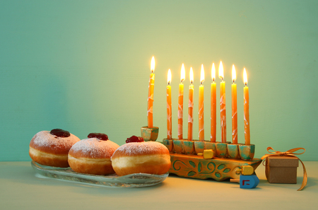 Image of Jewish holiday Hanukkah background with doughnuts and menorah (traditional candelabra)の写真素材