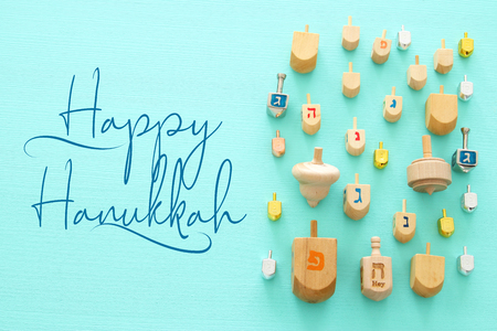 Image of jewish holiday Hanukkah with wooden dreidels colection (spinning top) over mint backgroundの写真素材