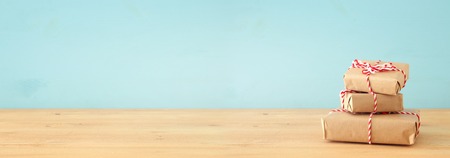 banner of handmade wrapped gift boxes over wooden tableの写真素材