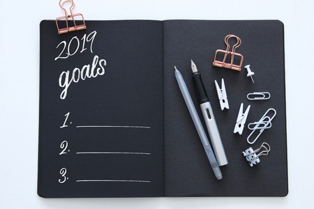 Top view 2019 goals list with notebook over wooden white deskの写真素材