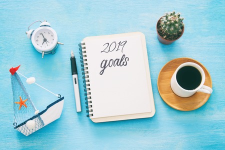 Top view 2019 goals list with notebook, cup of coffee over wooden deskの写真素材