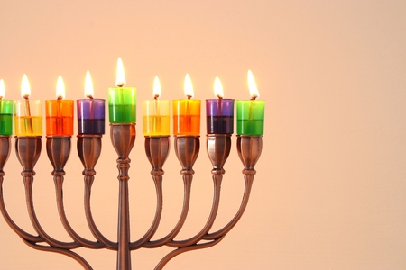 image of jewish holiday Hanukkah background with menorah (traditional candelabra) and colorful oil candlesの写真素材