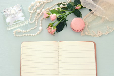 top view image of macaroons over wooden table, emprty notebook and flowersの写真素材