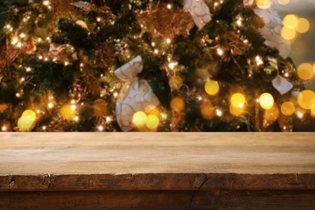 Empty table in front of christmas tree with decorations background. For product display montage