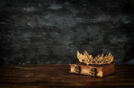 Low key image of beautiful queen crown on old book. Fantasy medieval period