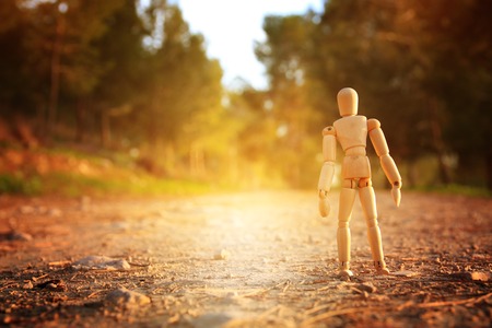 concept of vision and different thinking. wooden dummy standing on the road or path looking forwardの写真素材