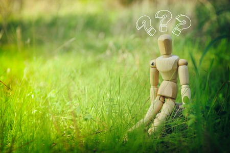 concept photo of wooden dummy sitting outdoors thinking. New idea concept or choosing the right solutionの写真素材