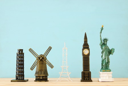 concept photo of some of the world famous landmark for travel , small statues over wooden tableの写真素材