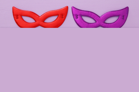 carnival party celebration concept with colorful masks over purple wooden background. Top viewの写真素材