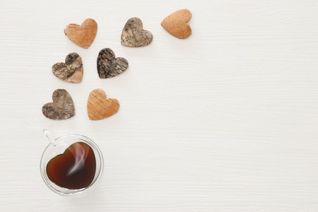 Valentine's day concept. Hearts cutted from tree trunk over wooden white backgroundの写真素材