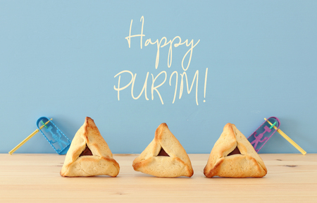 Purim celebration concept (jewish carnival holiday). Traditional hamantaschen cookies over wooden table and blue backgroundの写真素材