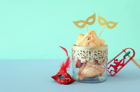 Purim celebration concept (jewish carnival holiday) over wooden table and mint backgroundの写真素材