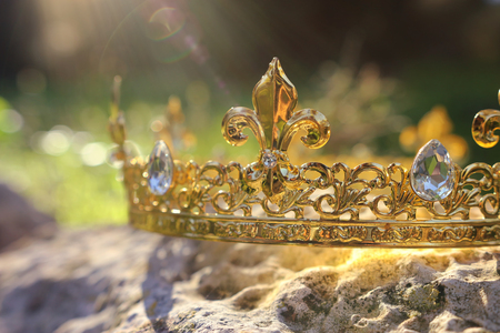 mysterious and magical photo of gold king crown over the stone in the England woods or field...