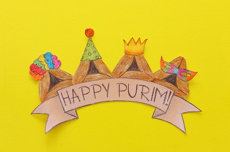 Purim celebration concept (Jewish carnival holiday). Traditional hamantash cookies cutted from paper and paintedの写真素材