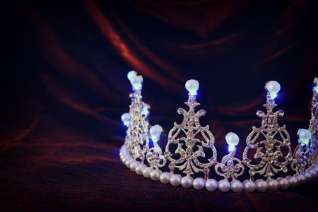 photo of gold crown over gothic dark silk background. Medieval period conceptの写真素材