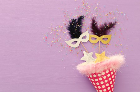 carnival party celebration concept with mask over purple wooden background. Top view. Flat layの写真素材