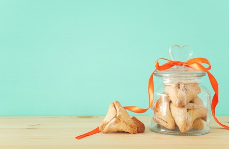Purim celebration concept (Jewish carnival holiday). Traditional hamantaschen cookies over wooden tableの写真素材