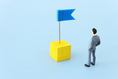 miniature people looking at destination pin signの写真素材