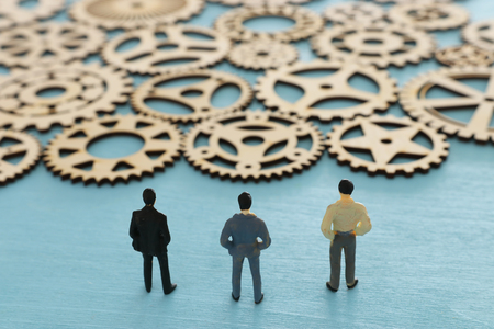 Miniature people looking at cogwheel in set of gears mechanism. Problem solving conceptの写真素材
