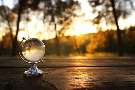 small crystal globe in front of sunset. travel and global issues conceptの写真素材