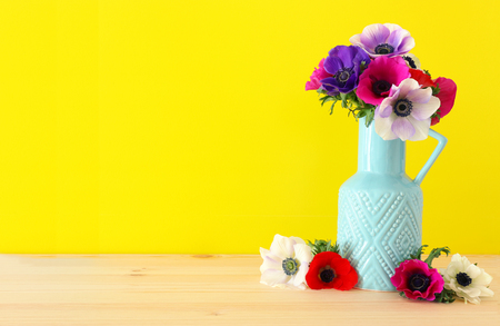 Spring bouquet of colorful anemones in the vase over wooden tableの写真素材