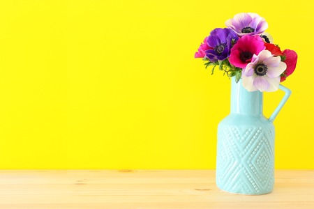 Spring bouquet of colorful anemones in the vase over wooden tableの写真素材