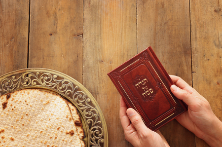 Pesah celebration concept (jewish Passover holiday). Traditional book with text in hebrew: Passover...