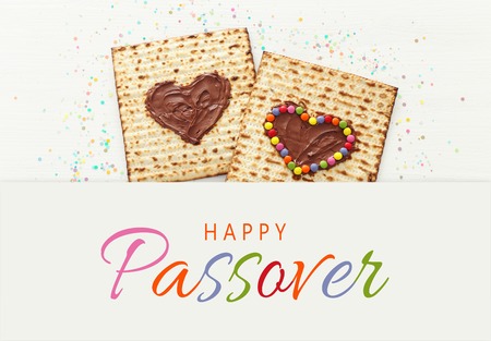 Pesah celebration concept (Jewish Passover holiday) with chocolate heart and colorful candies over matzah. Top view flat layの写真素材